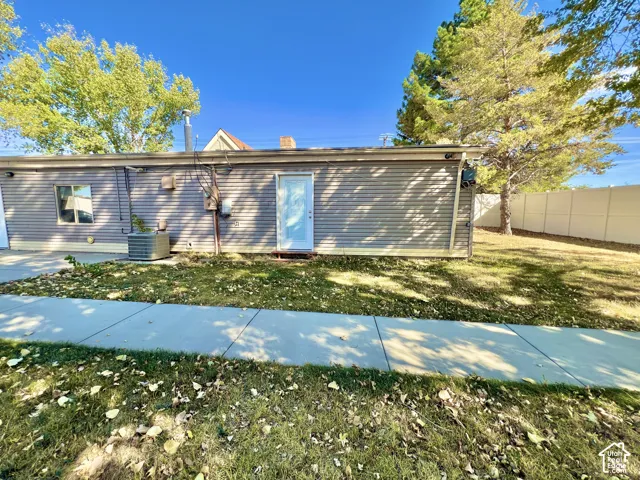 Rear elevation featuring horizontal siding, a white entry door, a single window, and a visible HVAC unit