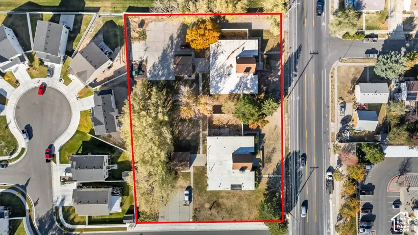 Expansive lot featuring two structures, mature trees, and direct road frontage