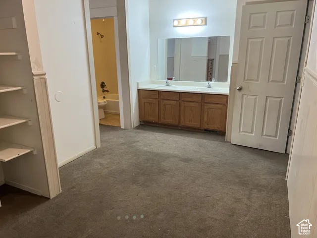 Double vanity with laminate countertops and wood-finish cabinetry
