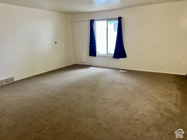 Spacious room featuring neutral carpeting and white wall finishes