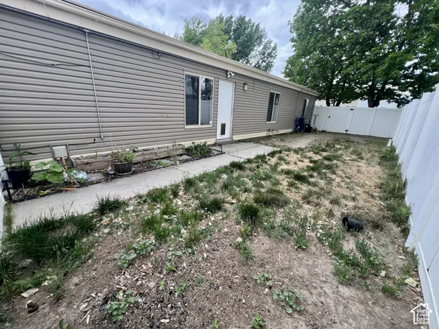 Exterior vinyl siding with multiple windows and a white privacy fence