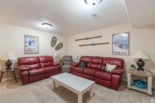 Carpeted recreation room featuring neutral wall tones and ceiling-mounted light fixtures