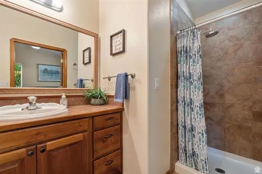 Bathroom vanity featuring a single basin sink, wood cabinetry, and a framed mirror