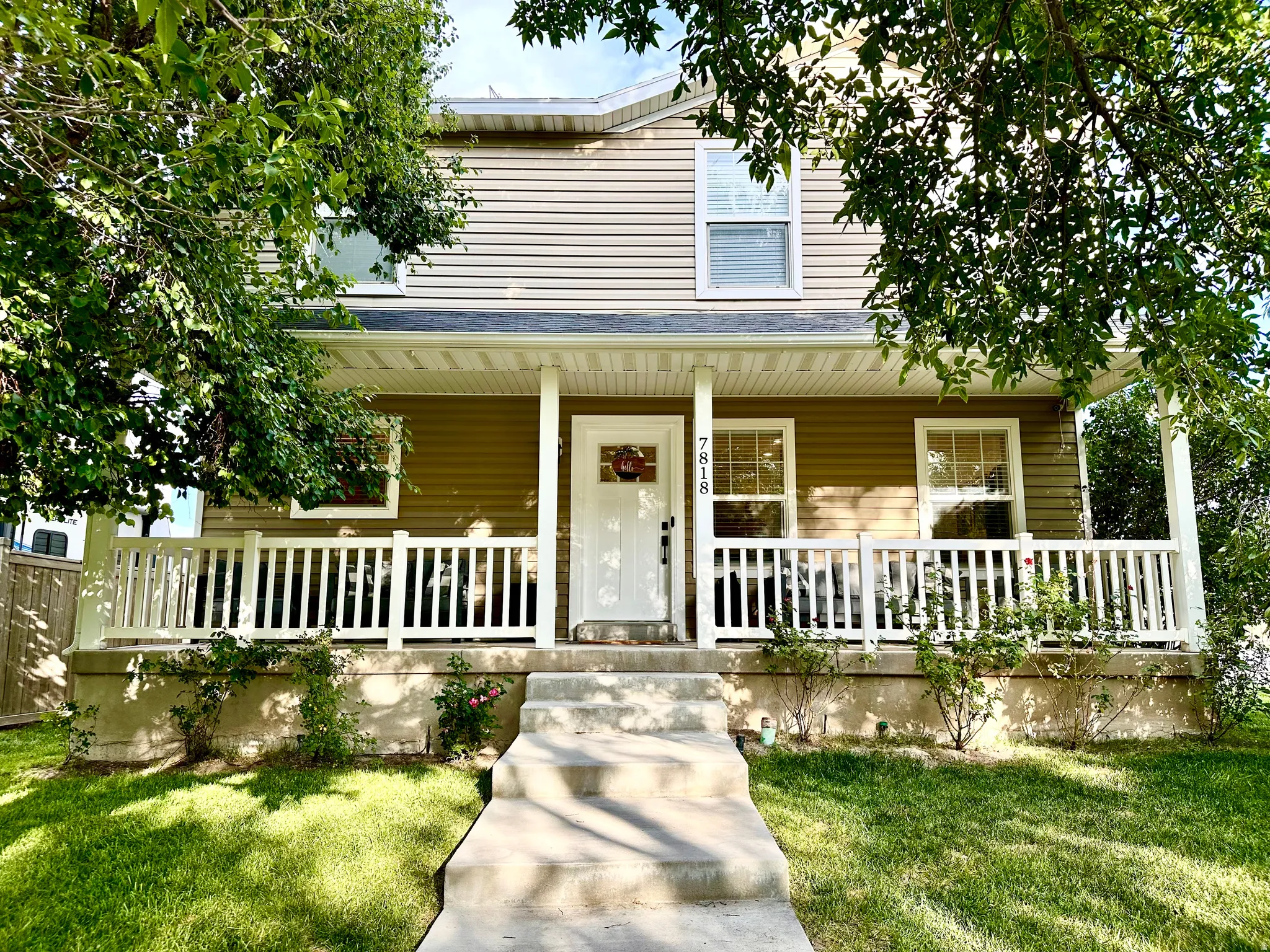 Two-story residence featuring tan horizontal siding and white trim