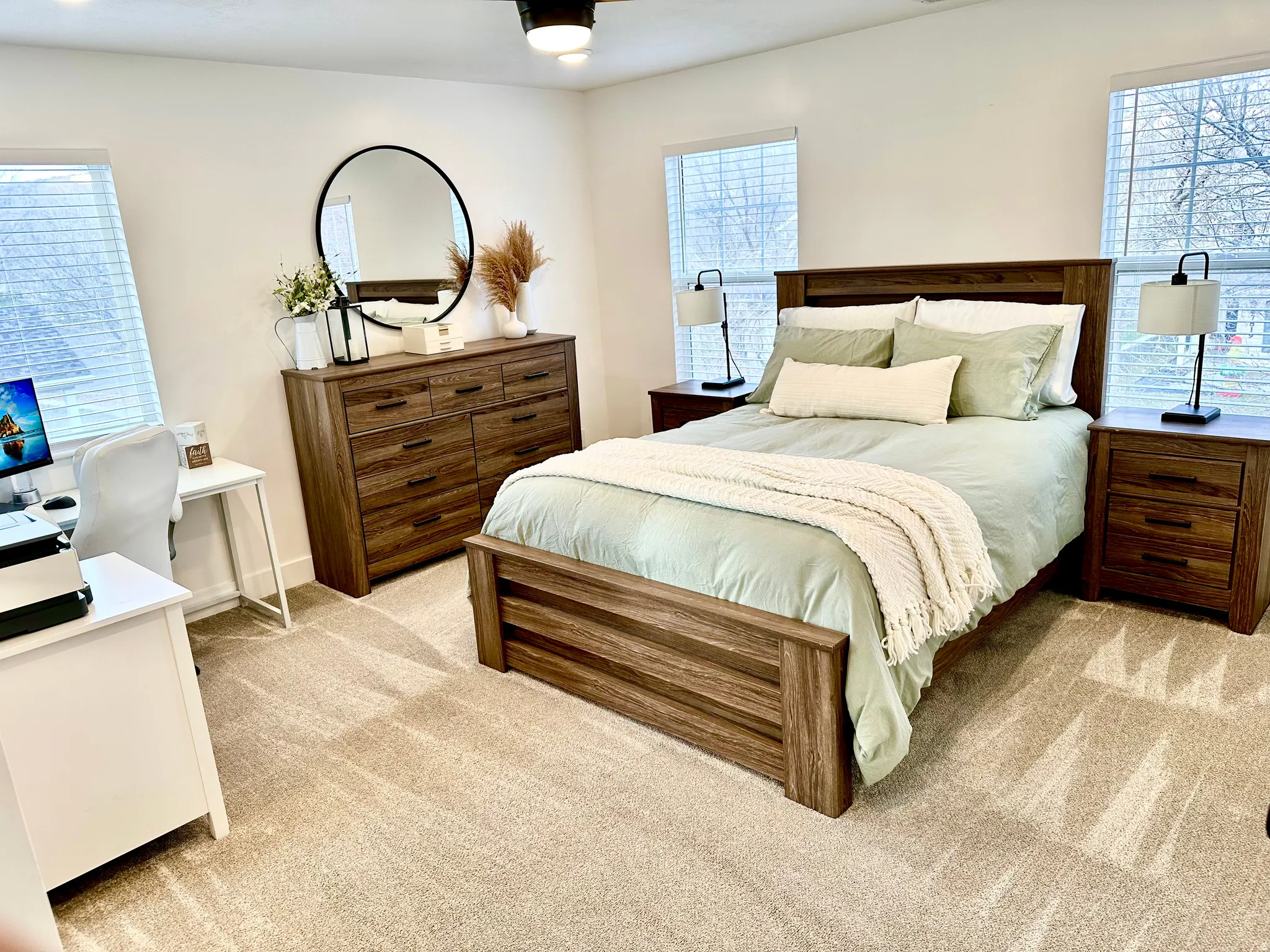Carpeted room featuring dual windows with blinds, a ceiling fan, and built-in lighting