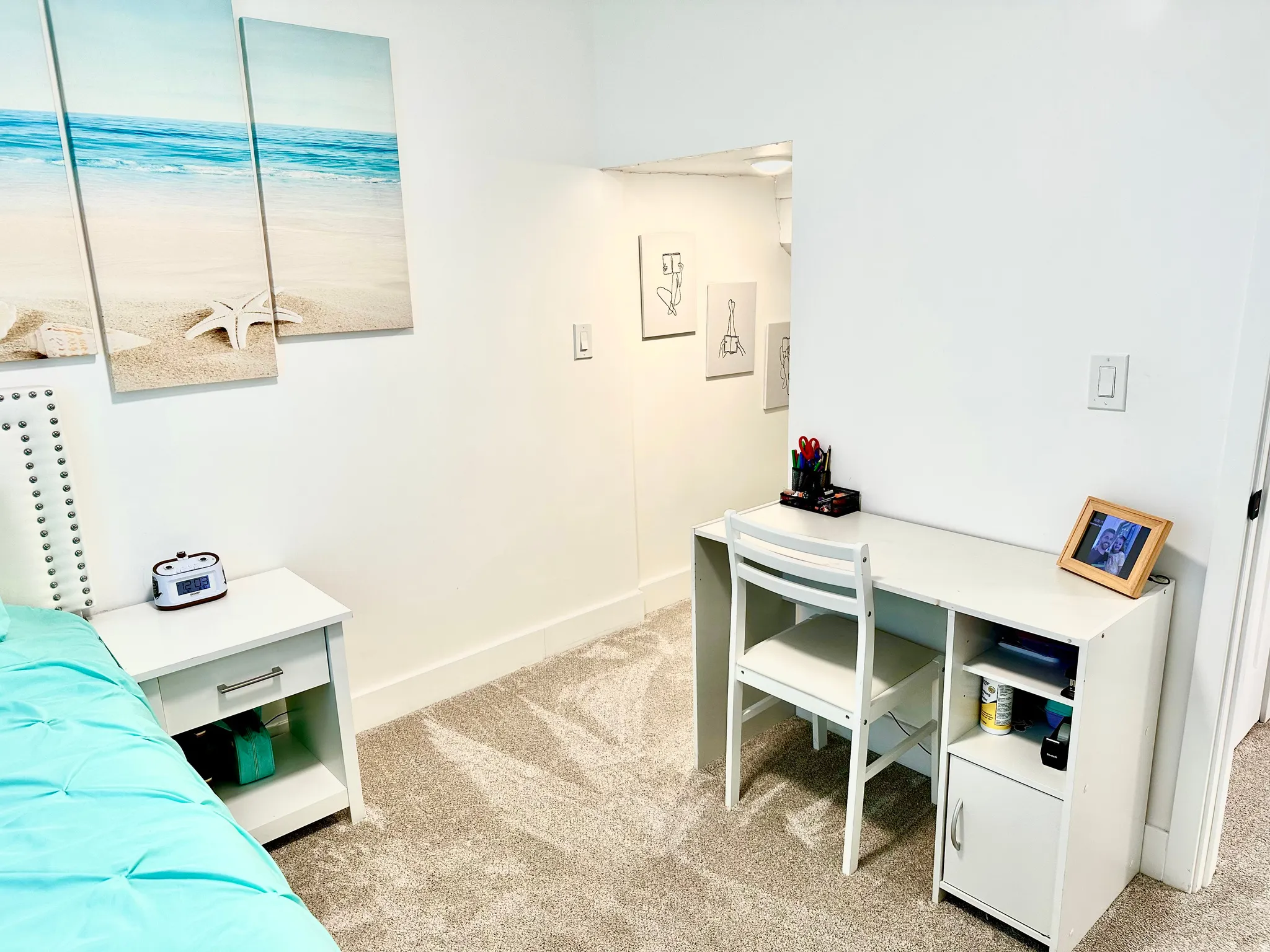 Neutral-toned carpeting spans the room, featuring white walls and baseboards