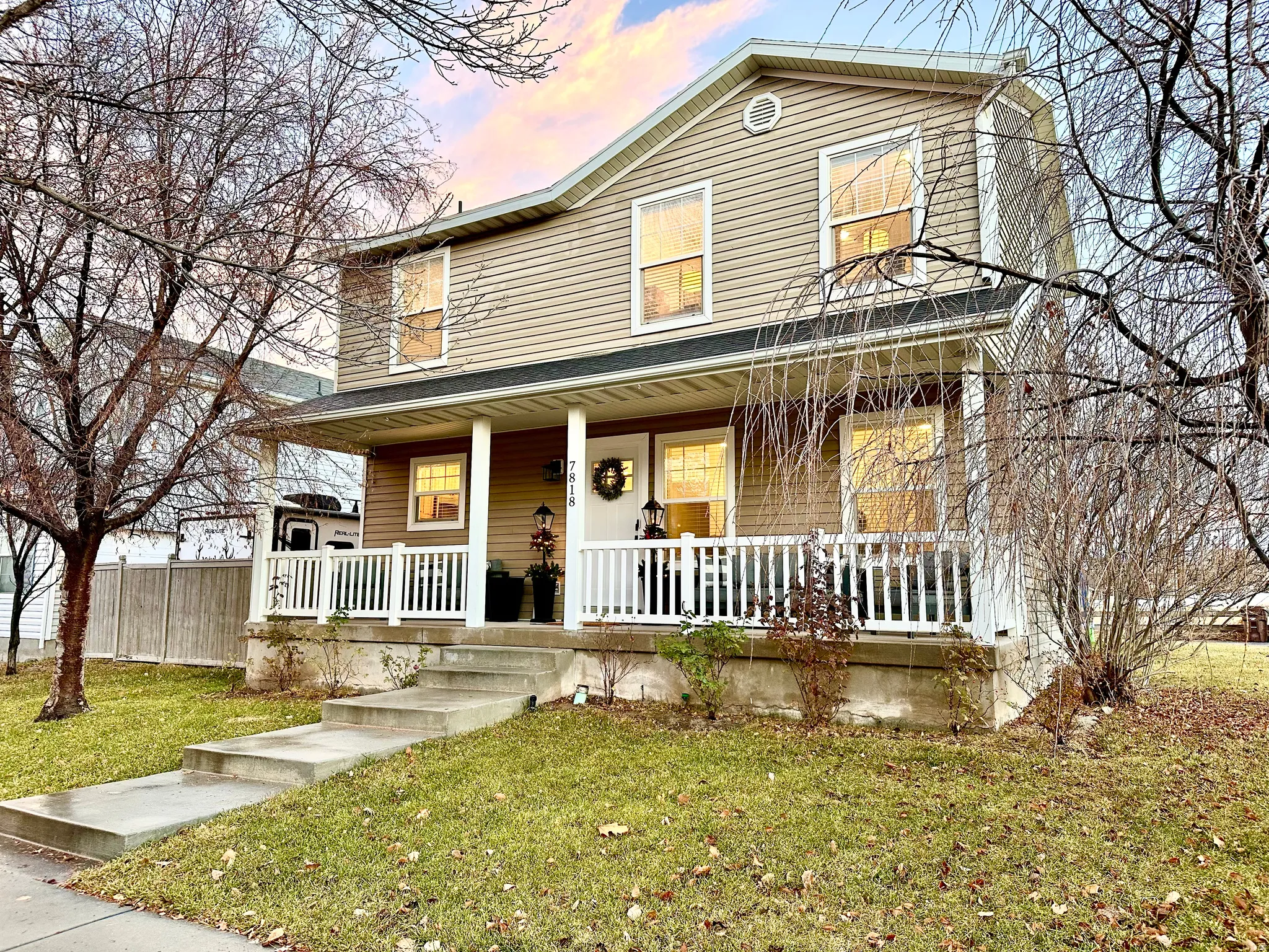 Two-story residence featuring light-colored siding and a covered front porch with white railings