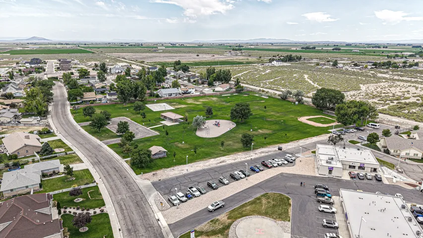 Aerial perspective showcasing residential properties bordering a community park with a playground structure and open green space