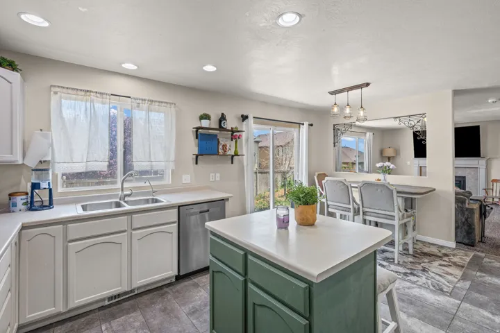 Kitchen featuring a two-tone cabinetry design, stainless steel dishwasher, double basin sink, and recessed lighting
