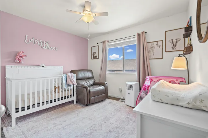 Room featuring a window with natural light, a ceiling fan fixture, and carpeting