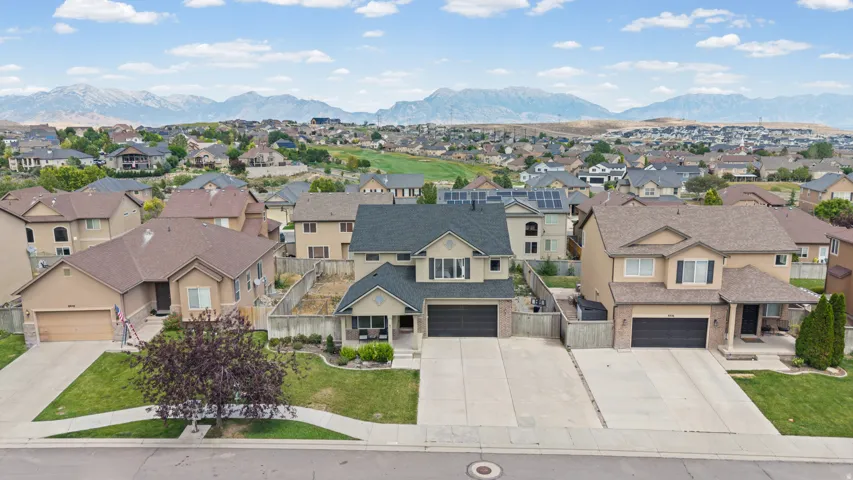 Two-story residence featuring a brick and stucco exterior, an attached two-car garage, and a landscaped front yard