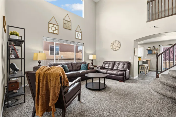 Living area with high ceilings, large windows, and an arched doorway