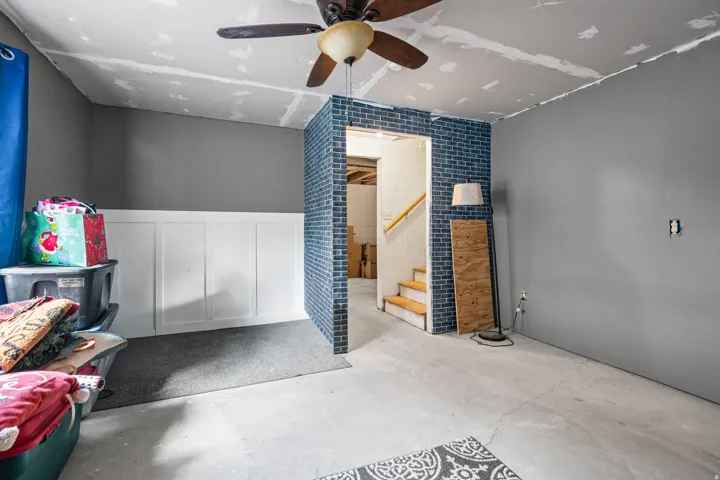 Unfinished interior space featuring a partial blue brick-style wall and an exposed concrete floor