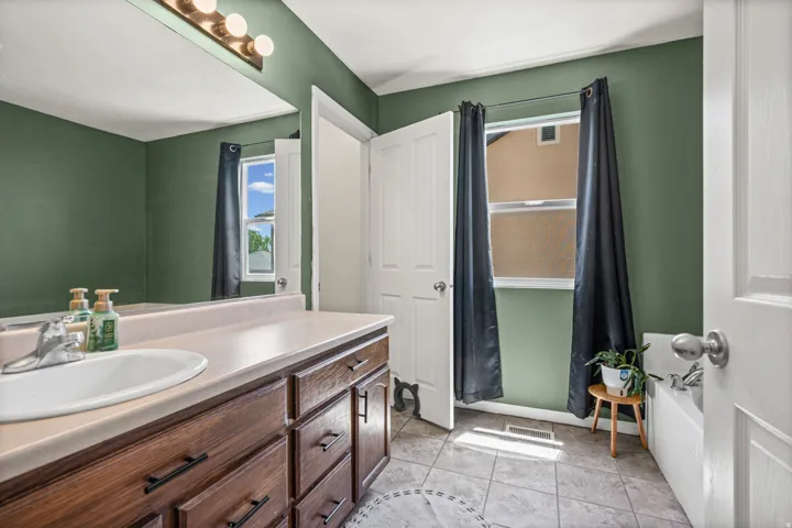 Bathroom vanity featuring wood-finish cabinetry with dark hardware and a built-in basin
