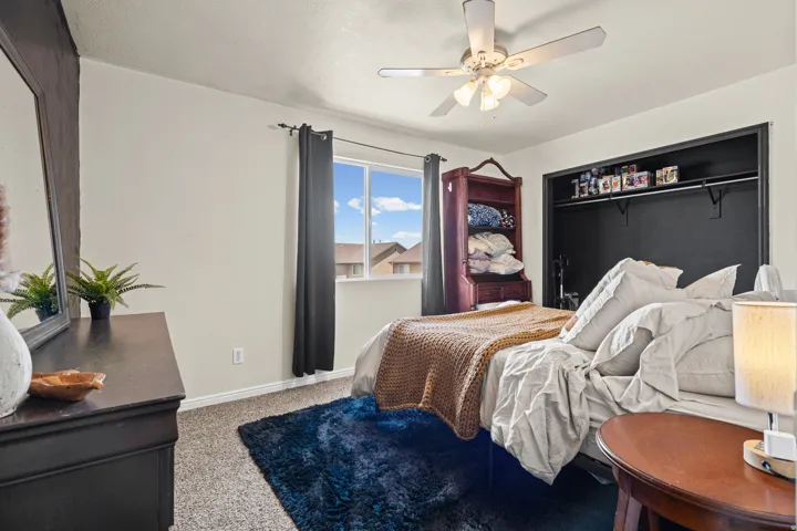 Room featuring a ceiling fan with integrated lighting, a window with dark curtains, and wall-to-wall carpeting