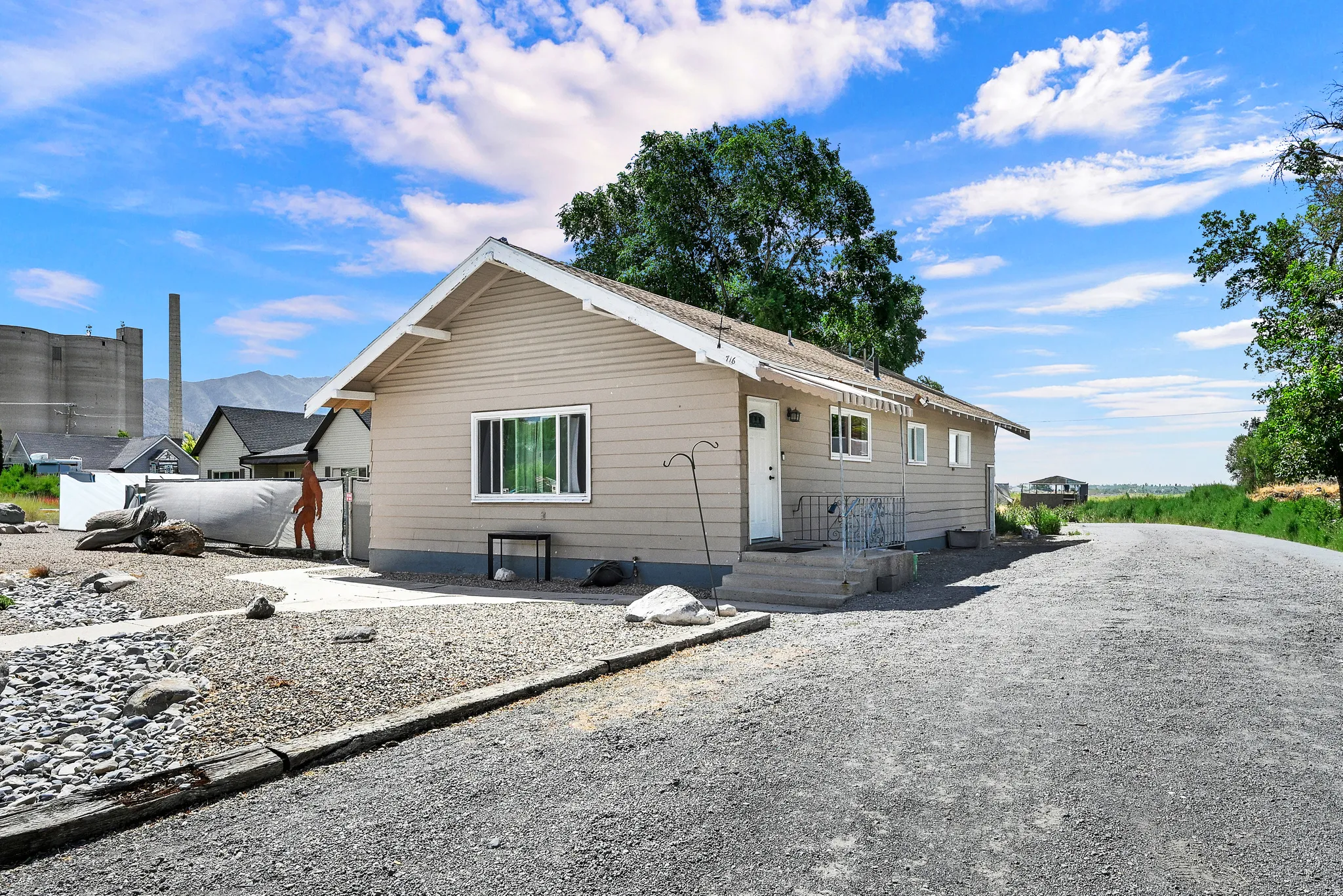 Ranch-style residence featuring horizontal siding and a gravel driveway