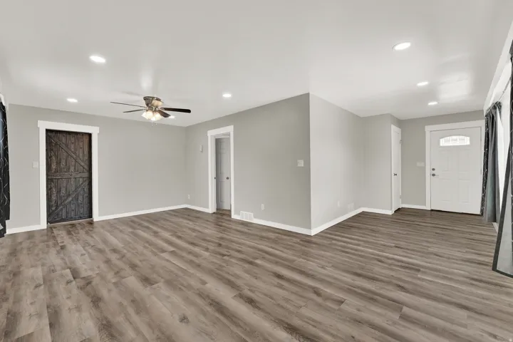 Spacious living area featuring wood-finish flooring, recessed lighting, and a ceiling fan