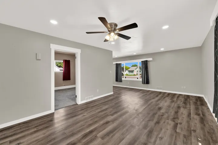 Spacious room featuring wood-finish flooring, recessed lighting, and a ceiling fan
