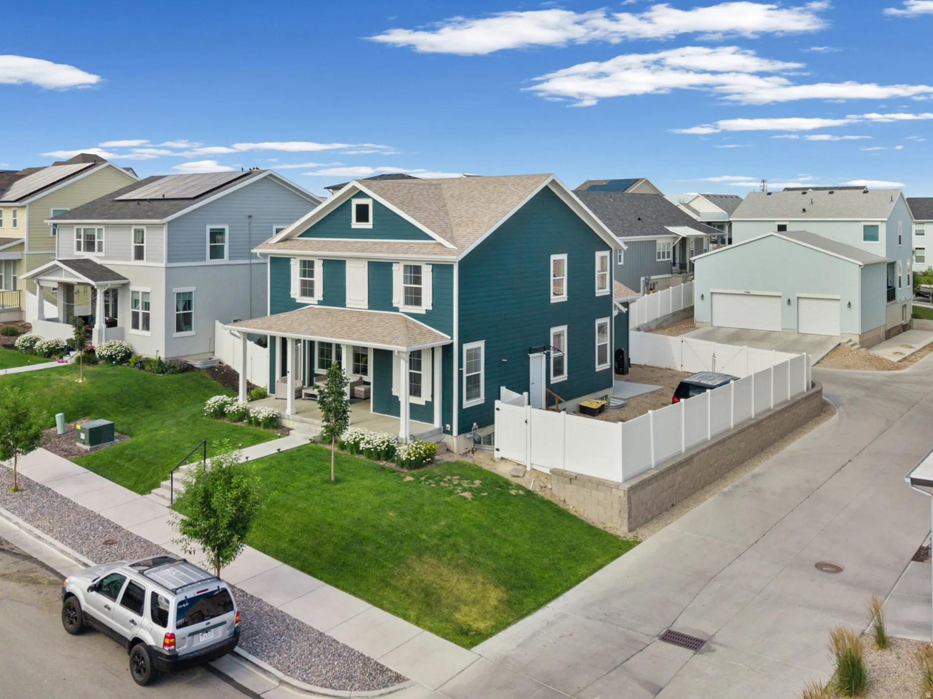Two-story residence featuring a covered front porch, white window trim, and a fenced backyard