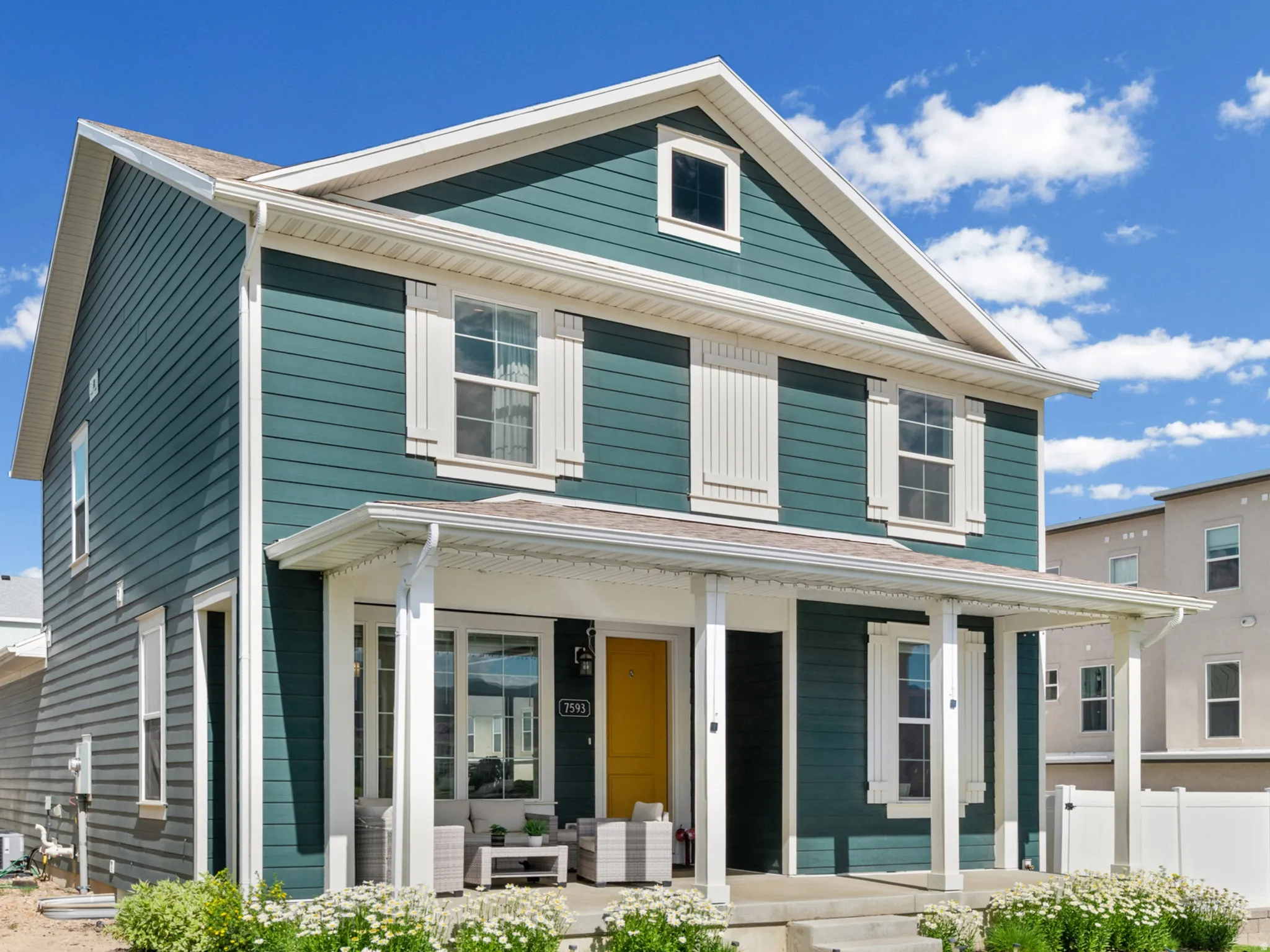 Two-story residence featuring teal horizontal siding and white trim