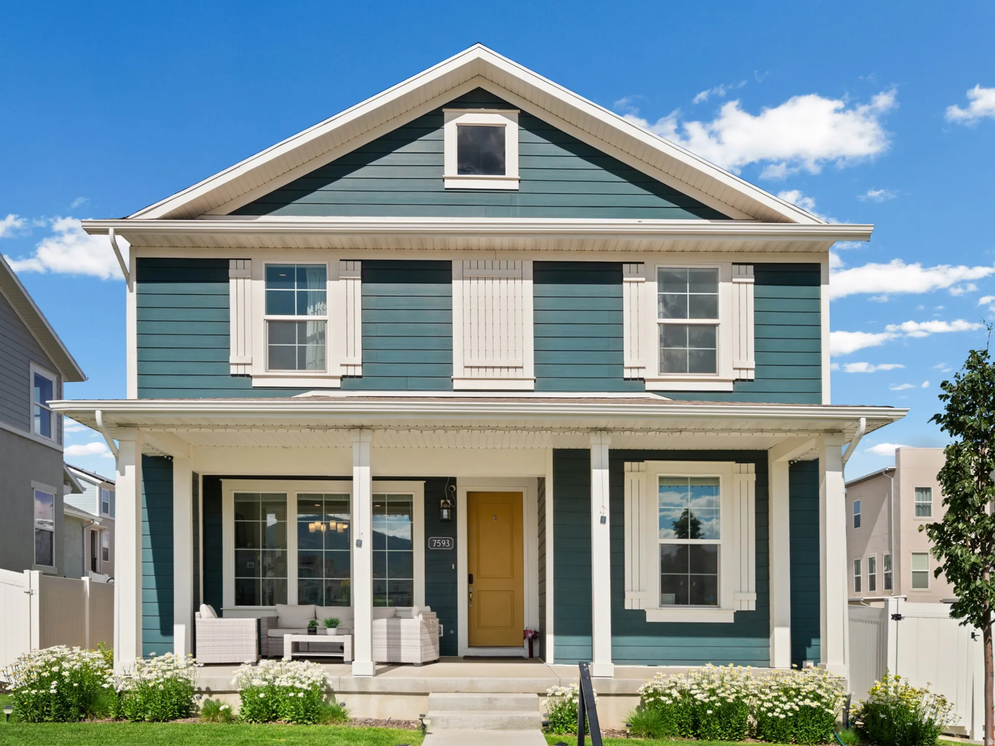 Two-story residence featuring teal horizontal siding and white trim