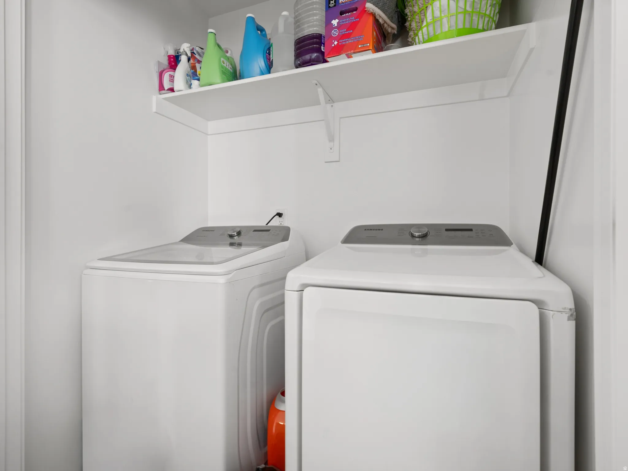 Dedicated laundry area featuring white walls and a built-in white shelving unit