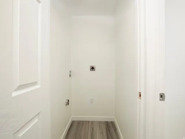Dedicated laundry alcove with wood-finish flooring