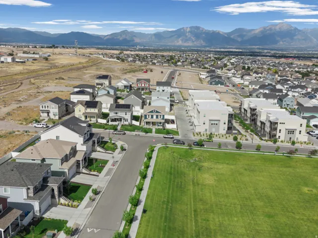 Expansive green space bordering a residential community with distant mountain ranges