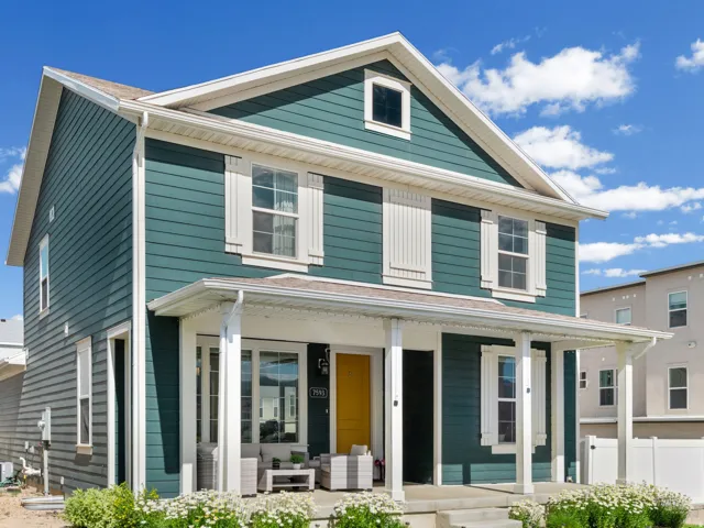 Two-story residence featuring teal horizontal siding and white trim
