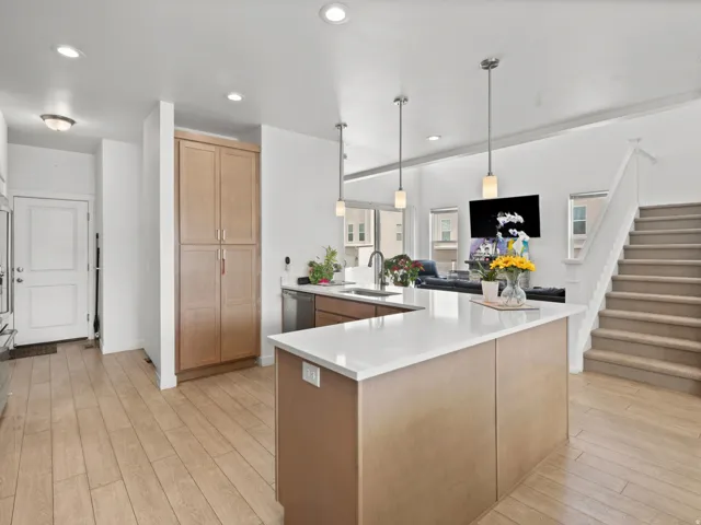Kitchen island featuring a white countertop, under-mount sink, and pendant lighting