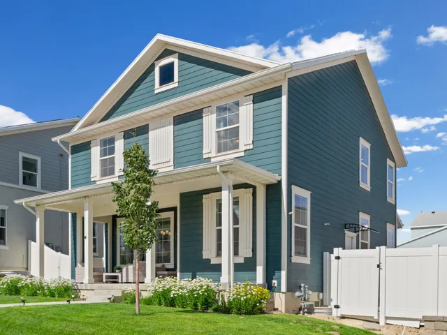 Two-story residence featuring deep teal siding and white trim