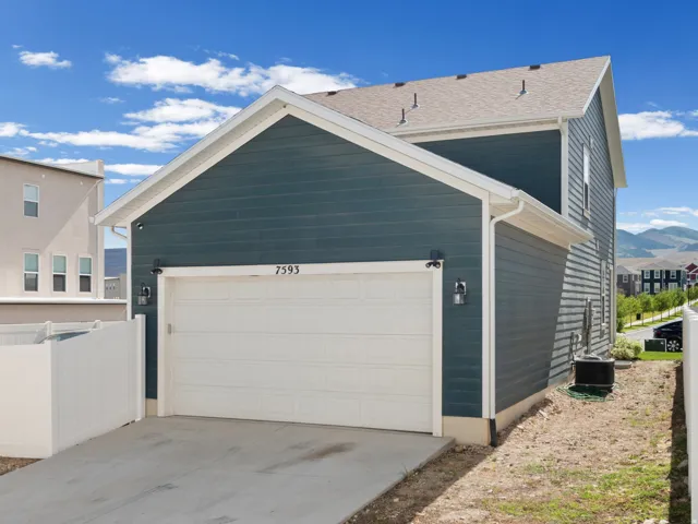 Attached two-story residence featuring a blue horizontal siding exterior and a white garage door