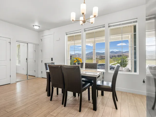 Dining area featuring wood-finish flooring, a modern chandelier, and multiple windows