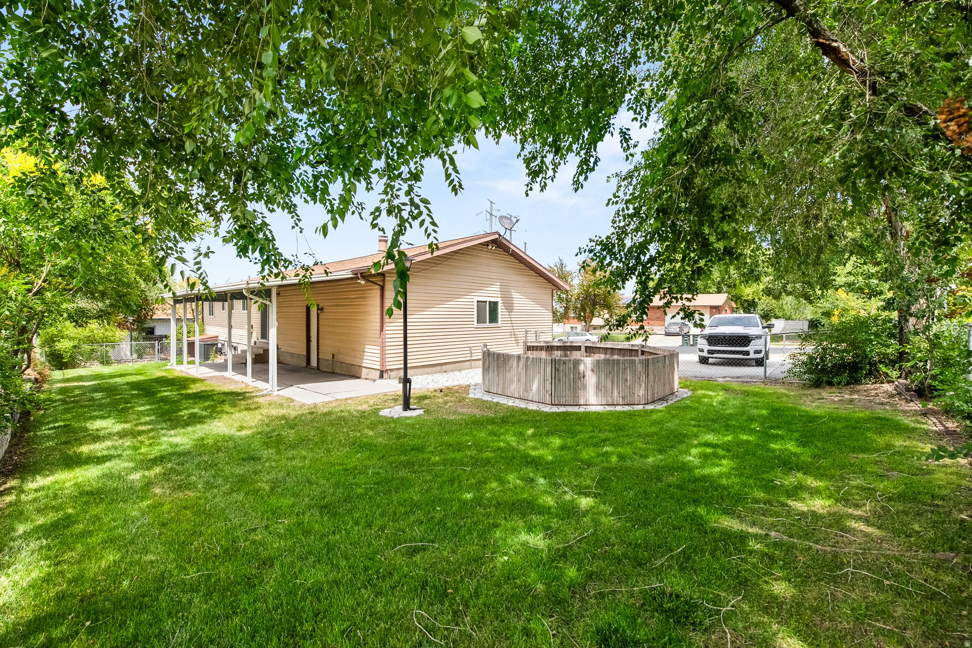 Expansive green lawn with mature trees providing partial shade