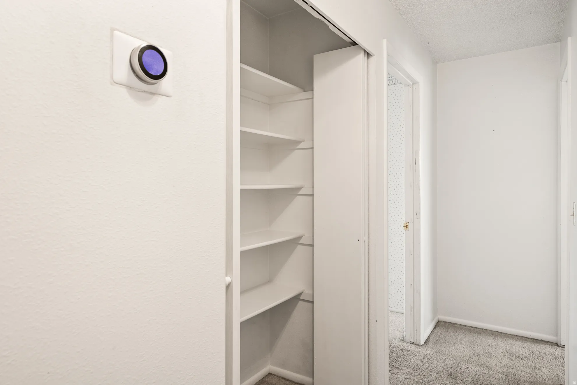 Built-in shelving unit providing ample storage, complemented by a smart thermostat