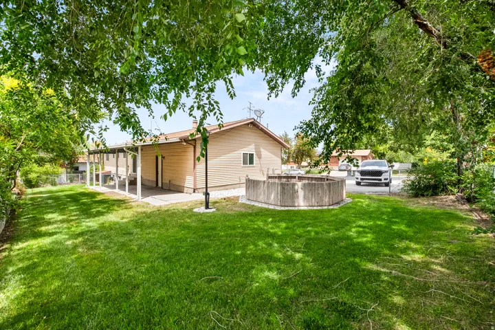 Expansive green lawn with mature trees providing partial shade