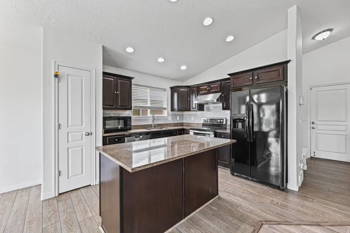 Functional kitchen with a center island, ample cabinetry, pantry, and recessed lighting. The layout offers excellent storage and workspace for daily use.