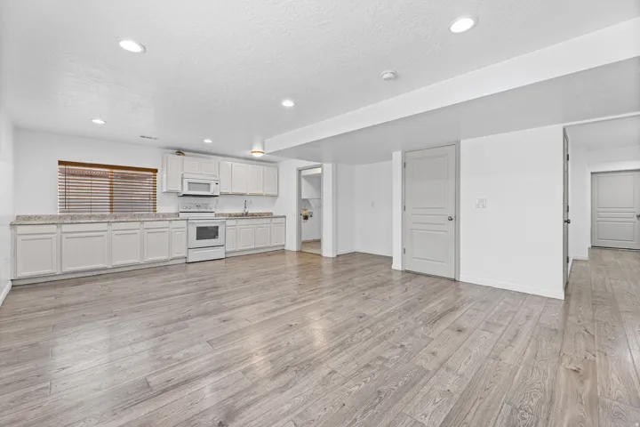 Expansive lower-level living area featuring an open floor plan with a full kitchen, recessed lighting, and generous space for relaxing, entertaining, or multi-generational living.
