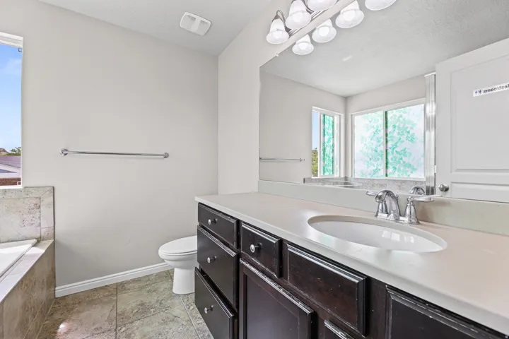 Primary bathroom with an extended vanity offering dual sinks, ample counter space, and natural light from a large window.