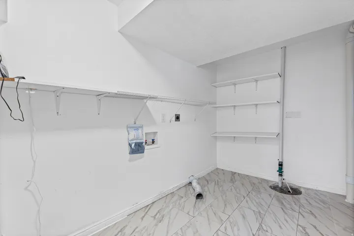 Dedicated laundry room with built-in shelving, hanging space, and additional room for storage and organization.