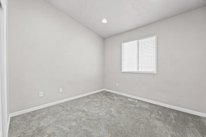 Comfortable secondary bedroom featuring a large window for natural light, neutral finishes, and a versatile layout suitable for a variety of uses