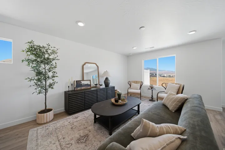 Bright living area featuring wood-finish flooring, recessed lighting, and large windows