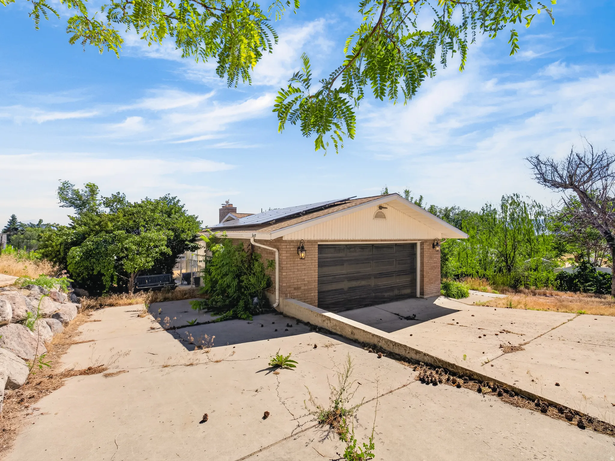 Attached two-car garage with a wood-finish door, brick exterior, and solar panels