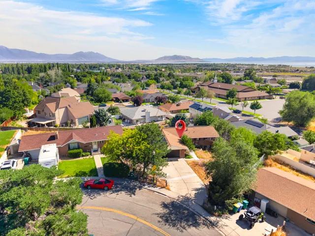 Aerial perspective showcasing a residential property with a brown shingle roof and an attached garage