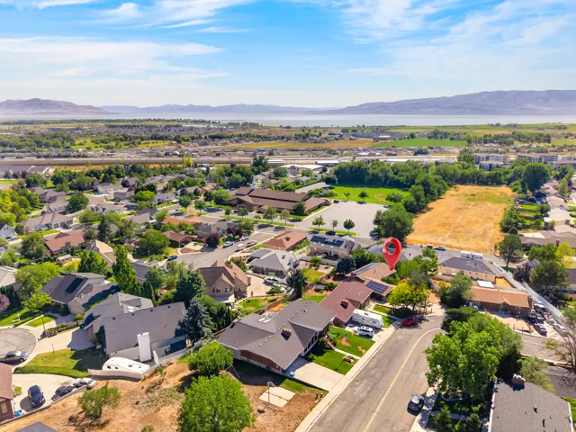 Aerial perspective of a residential neighborhood with distant mountains and a body of water