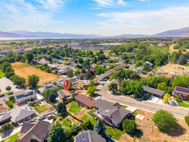 Aerial perspective showcasing a residential neighborhood with distant mountains and a body of water