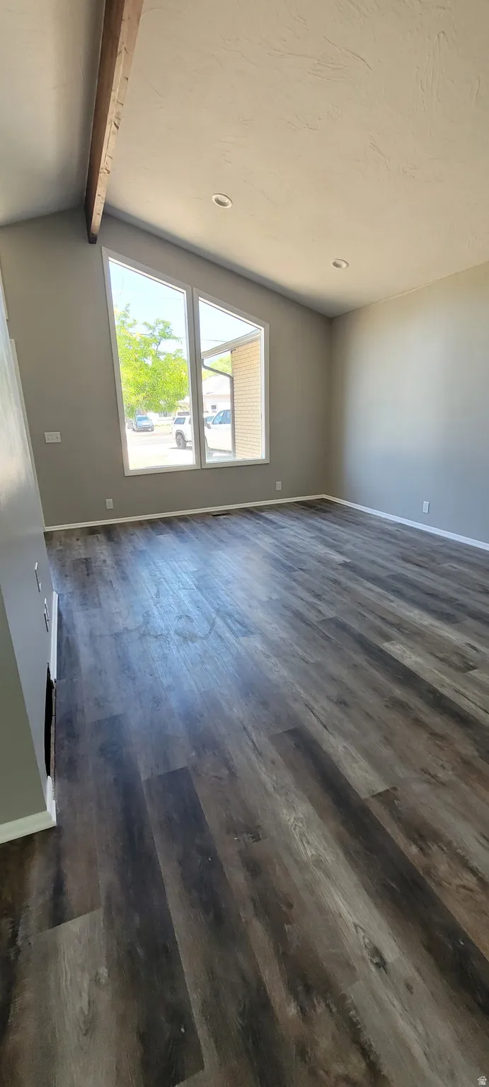 Spacious room featuring wood-finish flooring and neutral wall tones