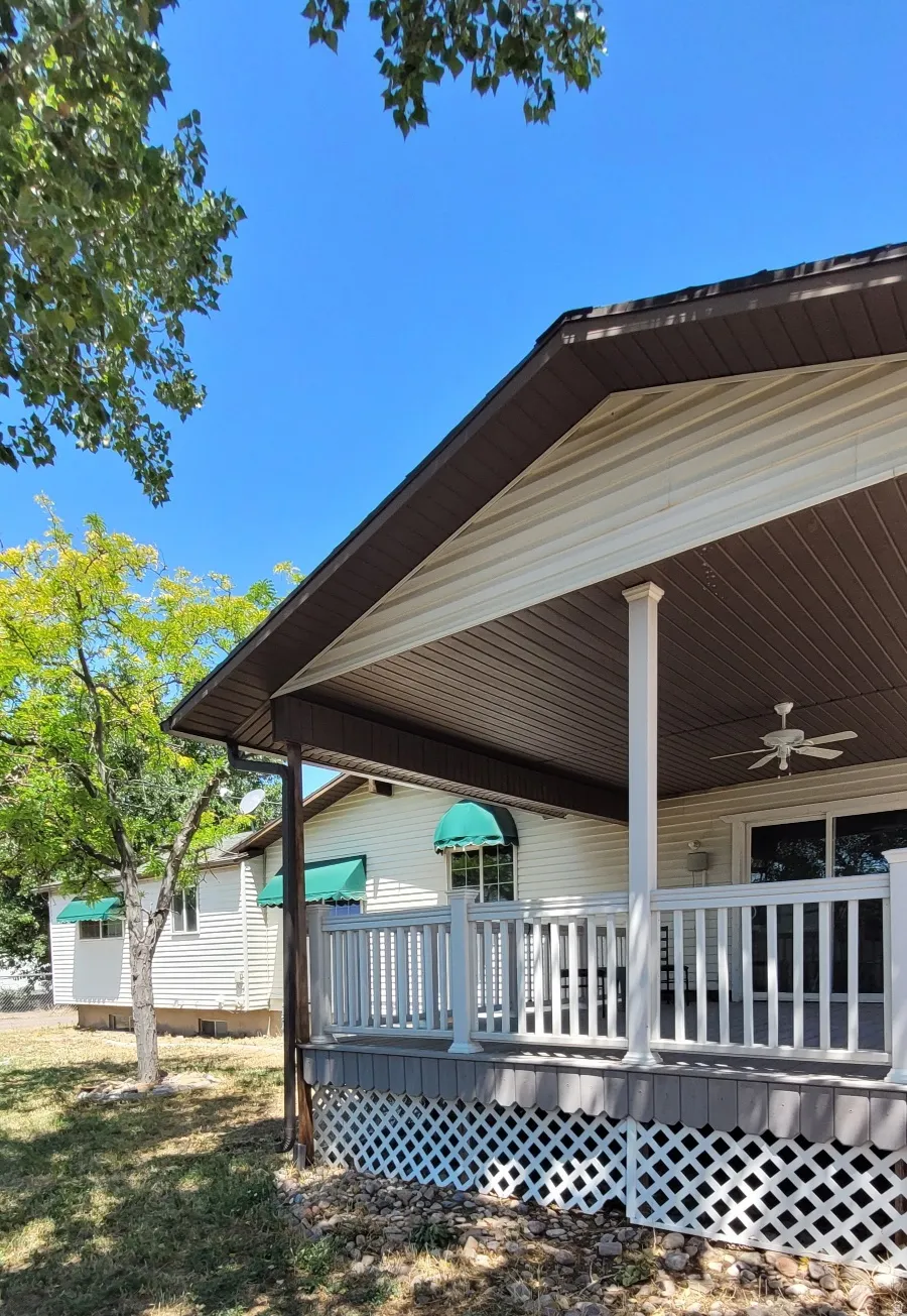Expansive covered porch featuring white railing and columns