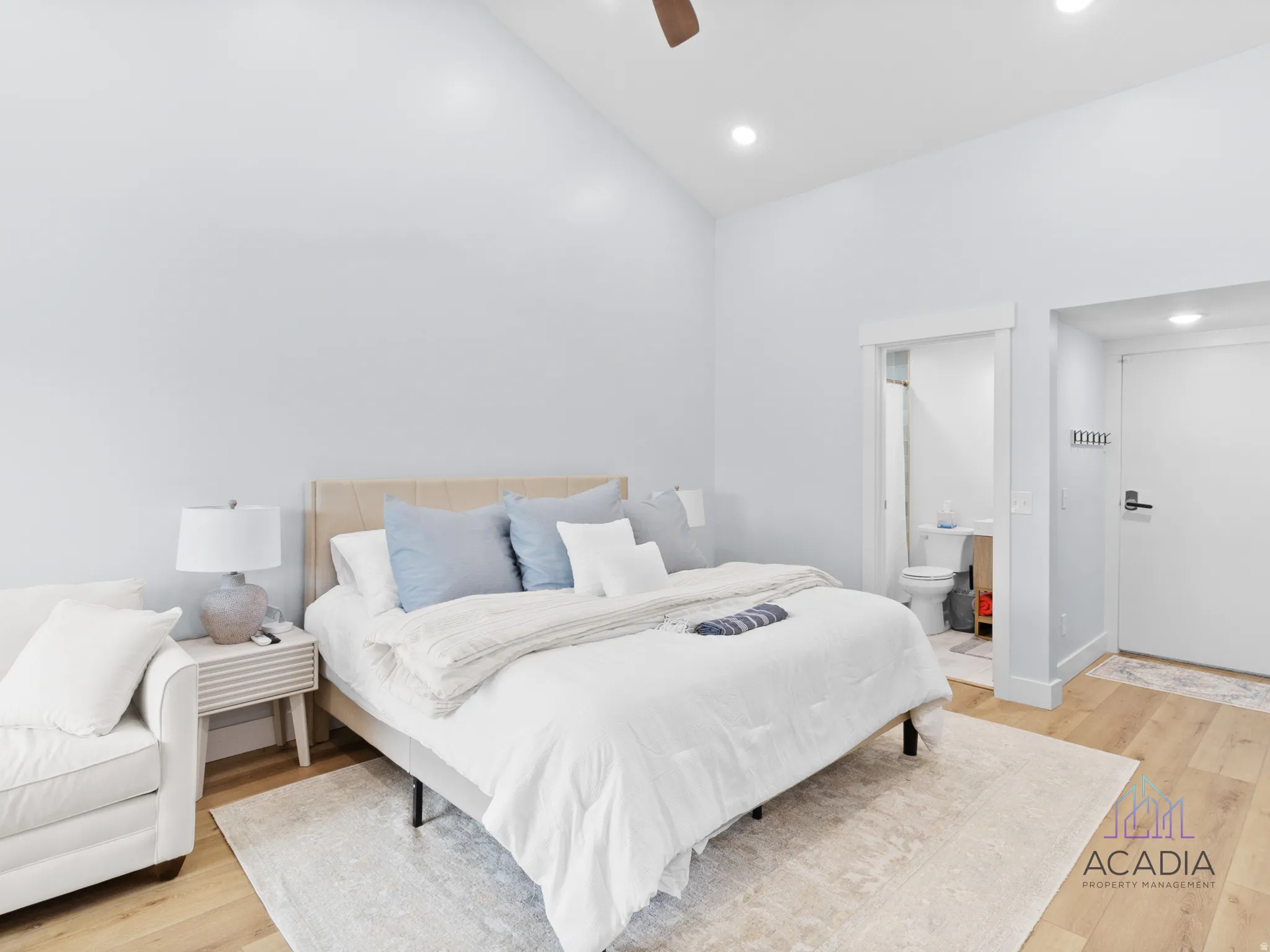 Vaulted ceilings accent this sleeping area featuring wood-finish flooring and recessed lighting