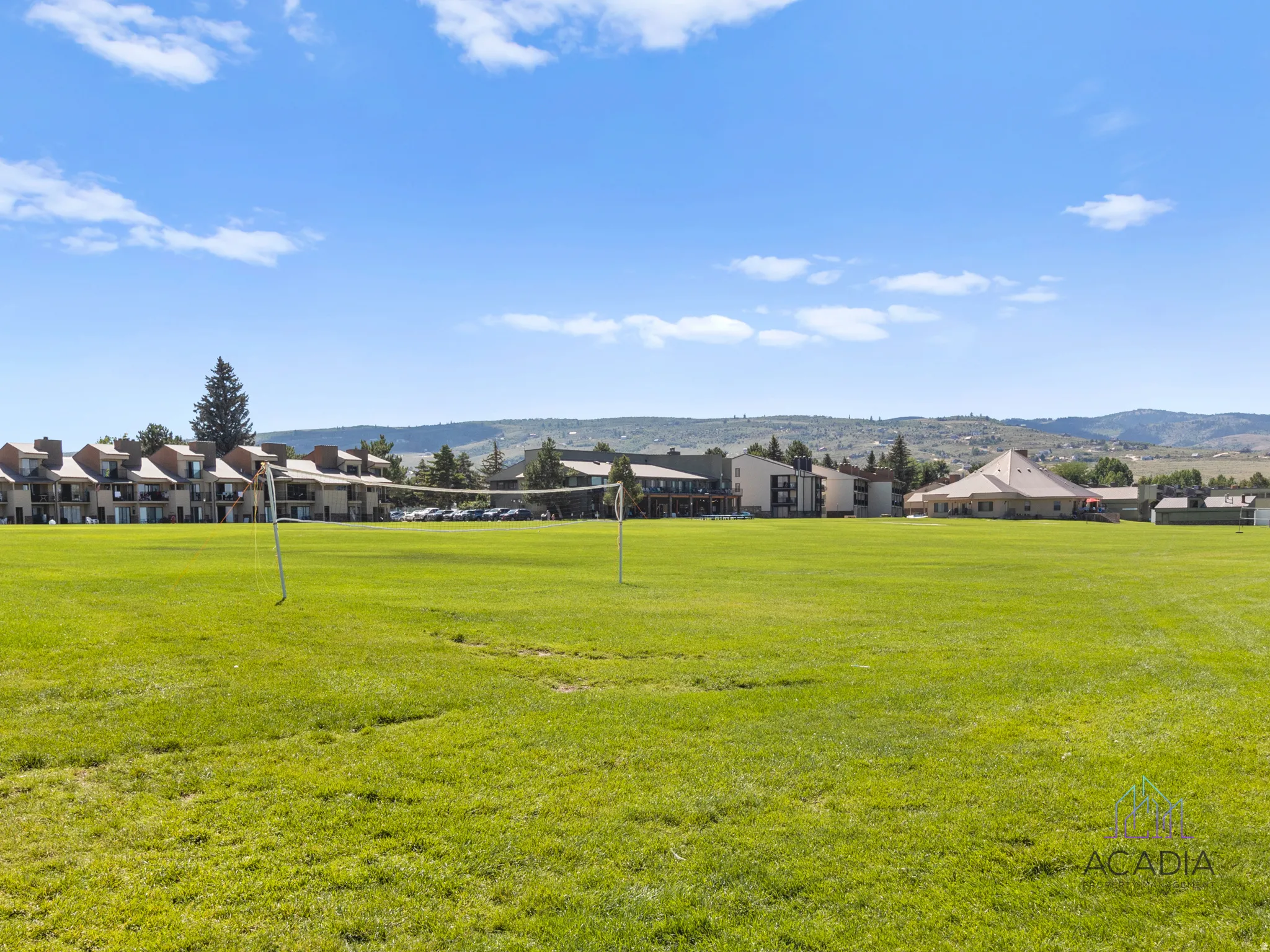 Expansive green space featuring a grass field and volleyball net